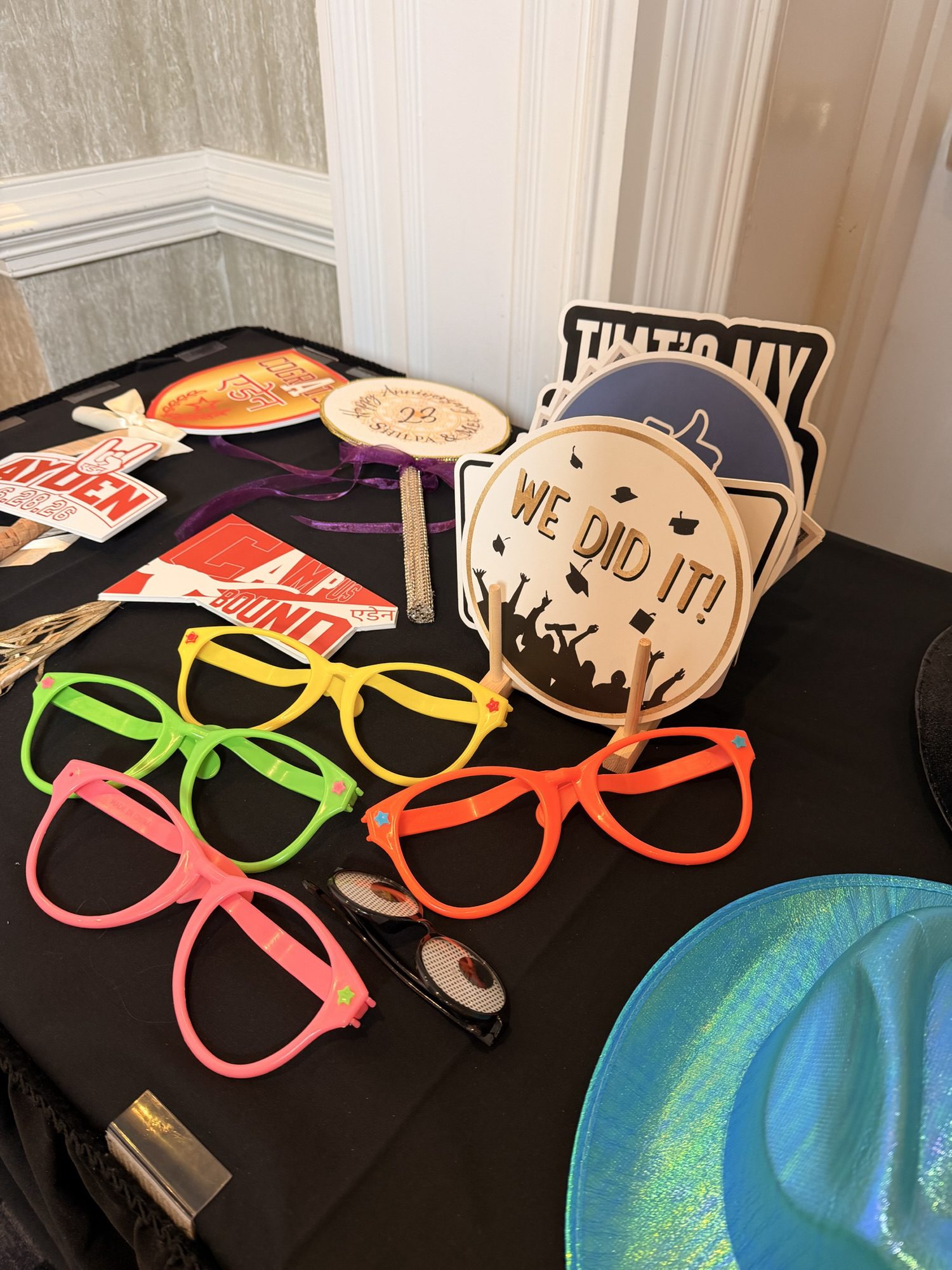 Photo booth props table with novelty signs at a wedding reception