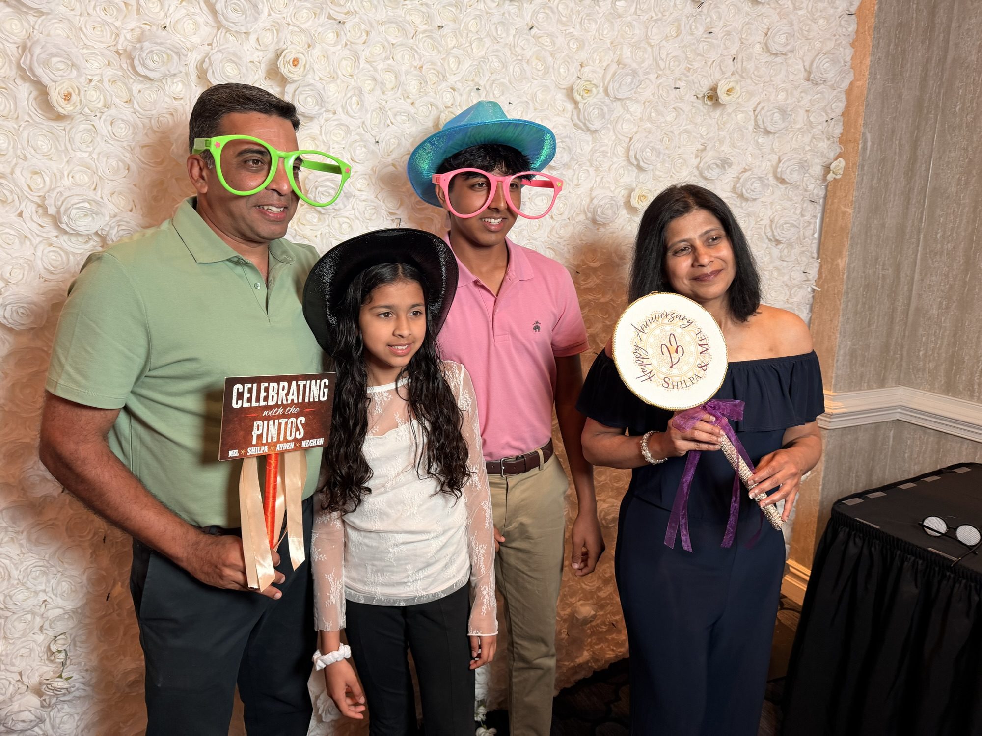Family celebrating with photo booth props and a personalized sign at a Bar Mitzvah